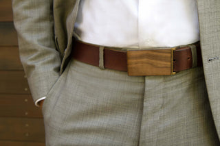 Wooden belt buckled being worn by a man in a gray suit
